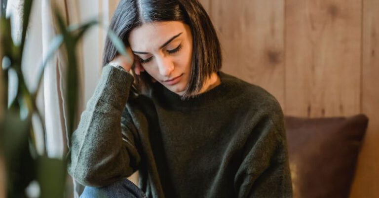 Progressive Overload - Tired female with closed eyes leaning on hand while having break and nap near window