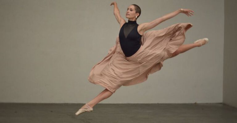 Static And Dynamic Stretching - Muscular female dancer rehearsing in spacious studio