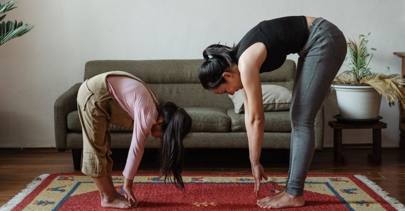 Stretch Times - Satisfied barefoot ethnic woman and cute daughter exercising together at home