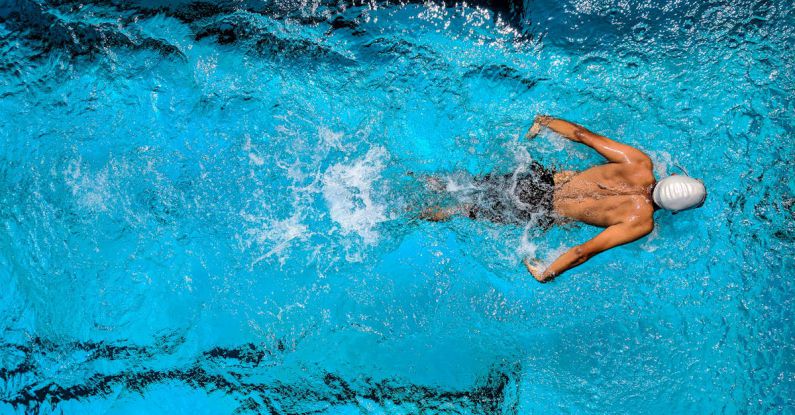 Swimming - Person Swimming on Body of Water